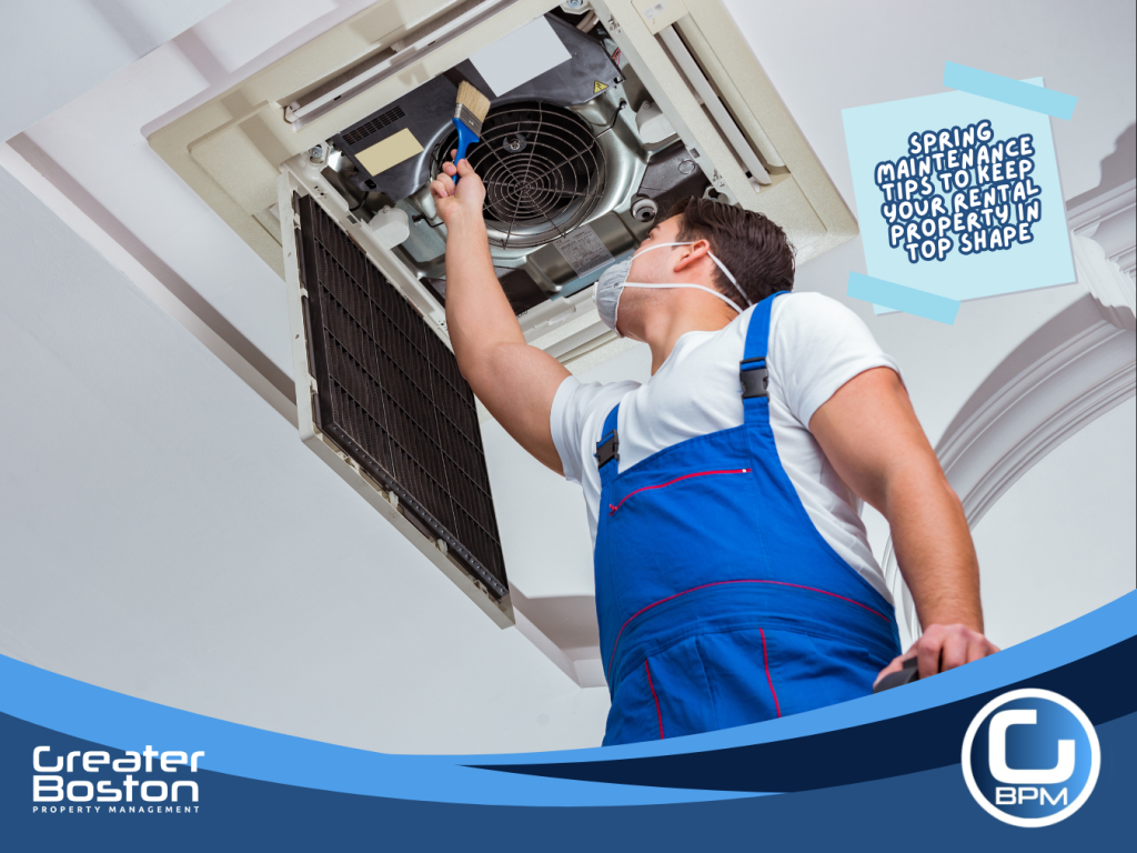 Technician cleaning indoor air conditioner unit during spring rental maintenance