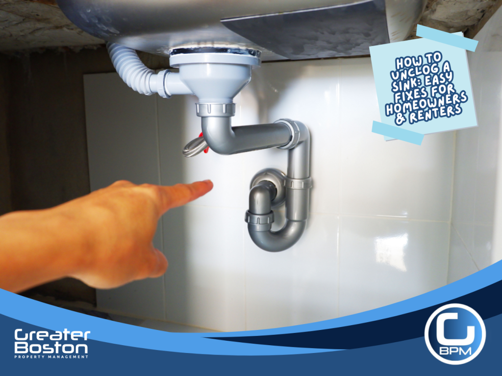 Pointing at the P-trap under a sink, a common spot for clogs