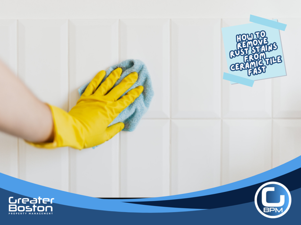Hand with yellow cleaning glove wiping ceramic tile wall to prevent rust stains and buildup