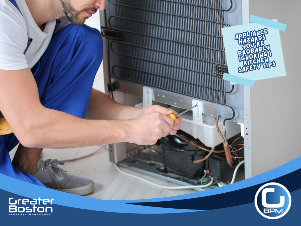 Technician cleaning and inspecting refrigerator coils to prevent overheating, electrical hazards, and hidden kitchen fire risks in rental properties.