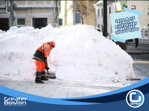 Landlord clearing snow and ice from rental property walkway in Massachusetts during winter storm for tenant safety