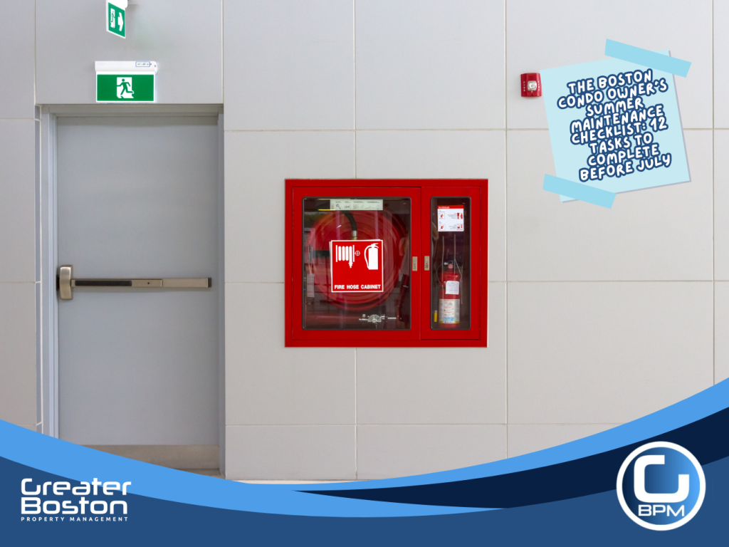 Boston condo building common area fire hose cabinet fire extinguisher and emergency exit signage representing summer safety and compliance inspection requirements for trustees in 2026