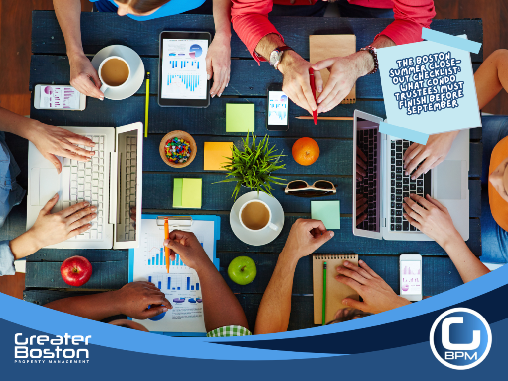 Boston condo management team collaborating around table with laptops tablets financial charts and reports representing the professional seasonal transition workflow that executes summer close-out and fall annual meeting preparation automatically in August 2026