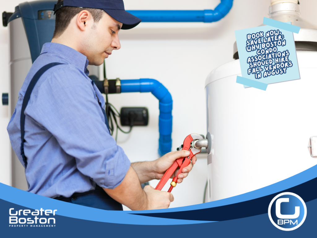 Licensed Massachusetts heating technician servicing boiler and hot water system with pipe wrench on Boston condo association building representing the pre-season heating system service Boston condo associations must book before September 1 to avoid October emergency rates in 2026